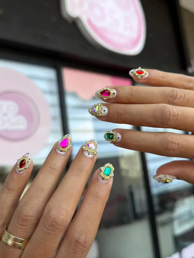 Uñas con gemas barrocas frente a punto.rosa
